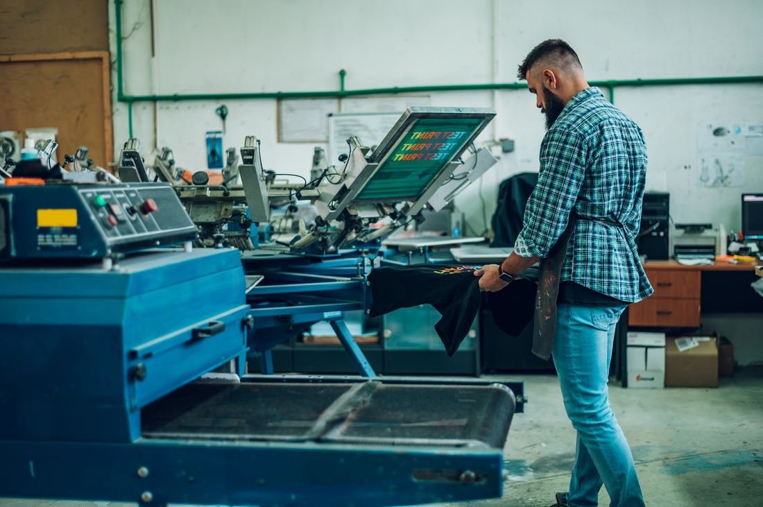Worker holding a freshly screen printed t-shirt